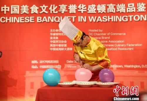 当地时间5月26日晚，由中国烹饪协会会长姜俊贤率领的美食代表团在华盛顿中国城举办品鉴中国美食文化的活动。图为湖北名厨伍峰表演“气球上切肉丝”。　邓敏 摄